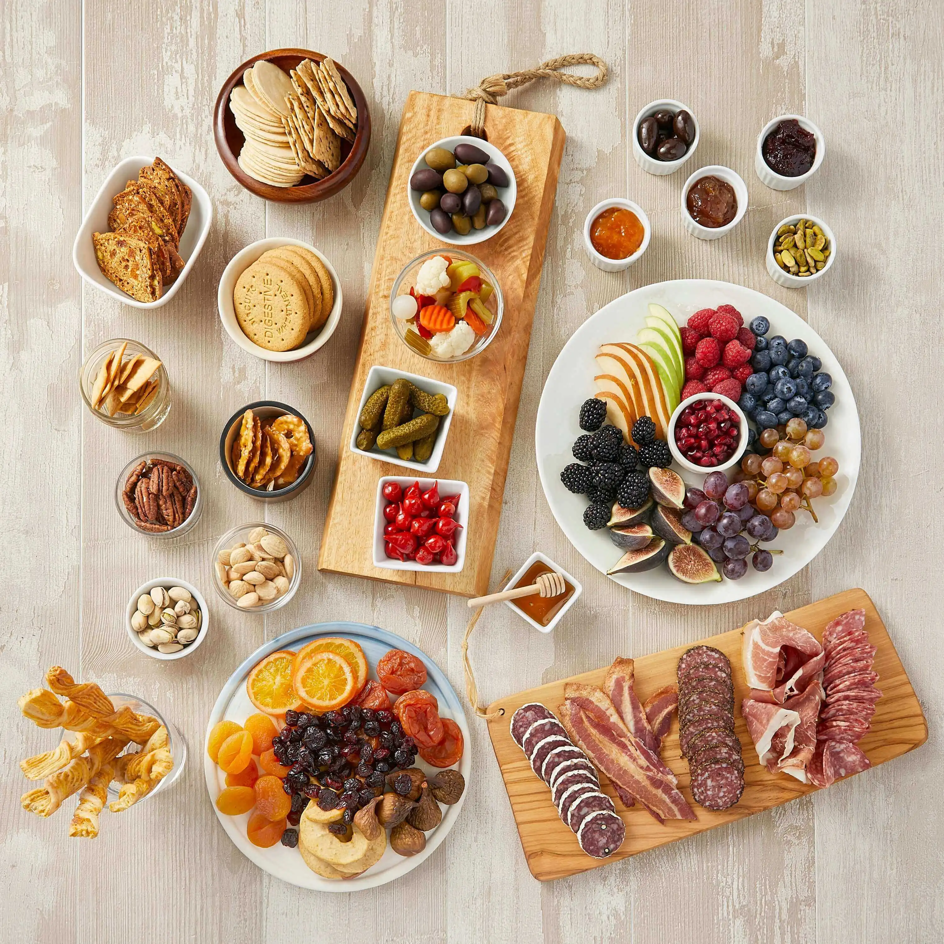 Various platters showcasing a myriad of cheese platter pairings including crackers, fresh and dried fruits, and cured meat.