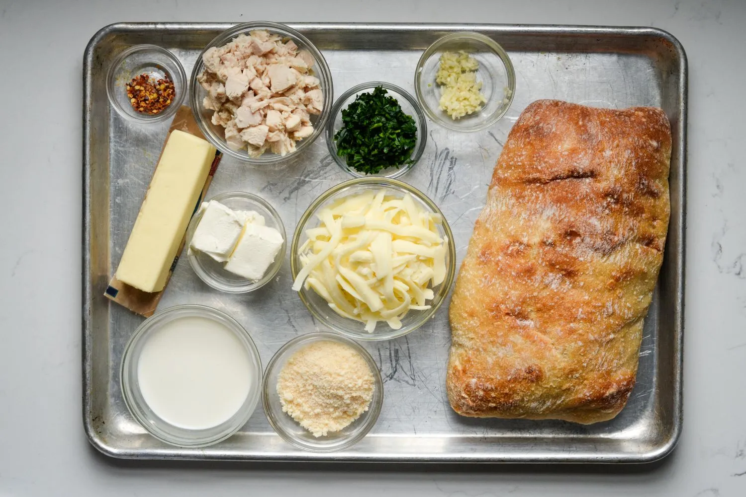 Ingredients for cheesy chicken alfredo garlic bread.