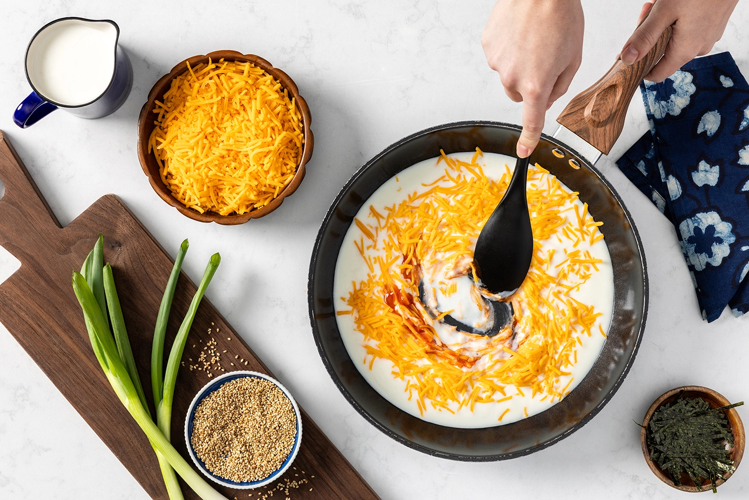 butter, garlic, milk, cheddar cheese, and sriracha cooked in a large skillet until melted and smooth.