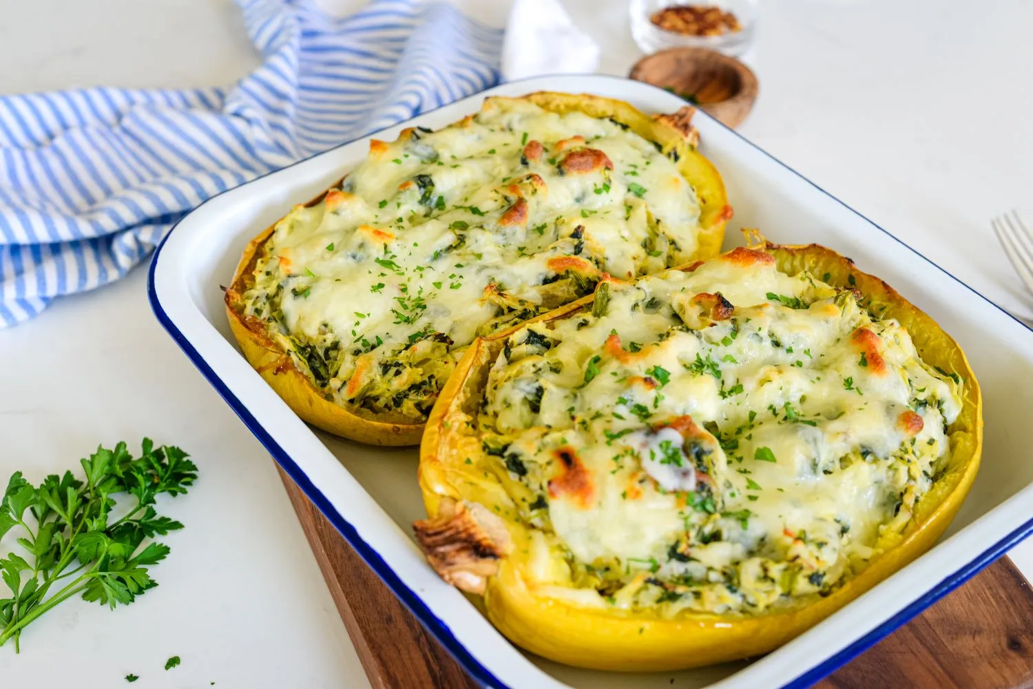 Cheesy spinach artichoke stuffed spaghetti squash served in a baking dish