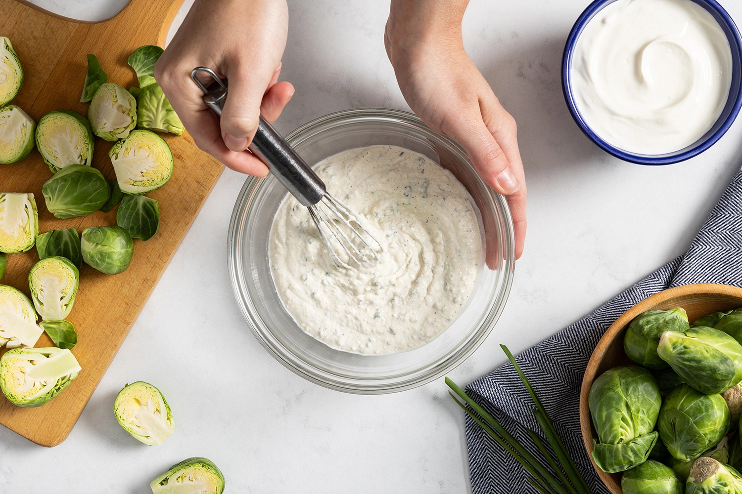 Dijon chive cream sauce mixed in a bowl to pair with Parmesan crusted Brussels sprouts.