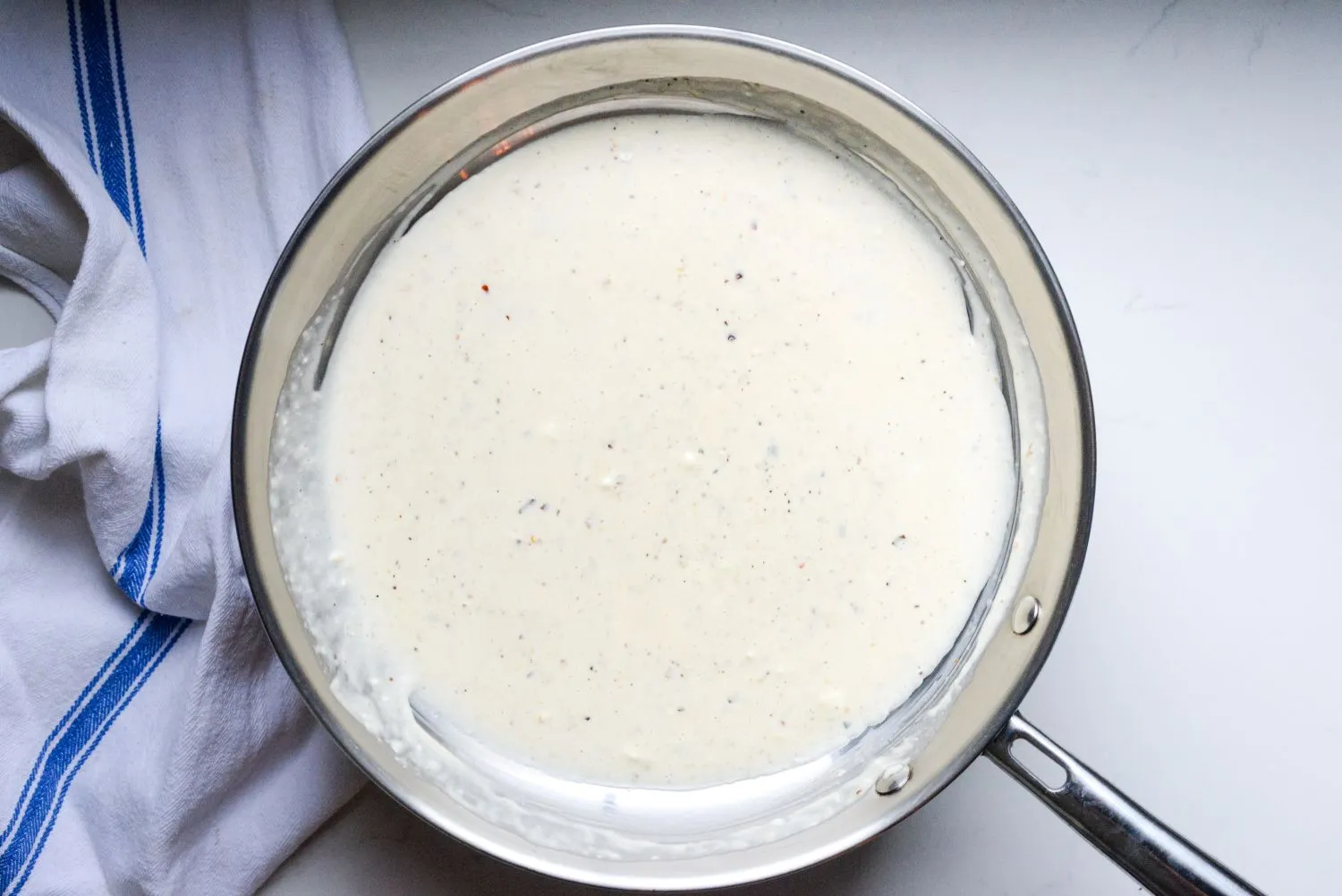A softened sauce mixture of garlic, butter, Cream cheese, and Parmesan cheese in a hot pot.