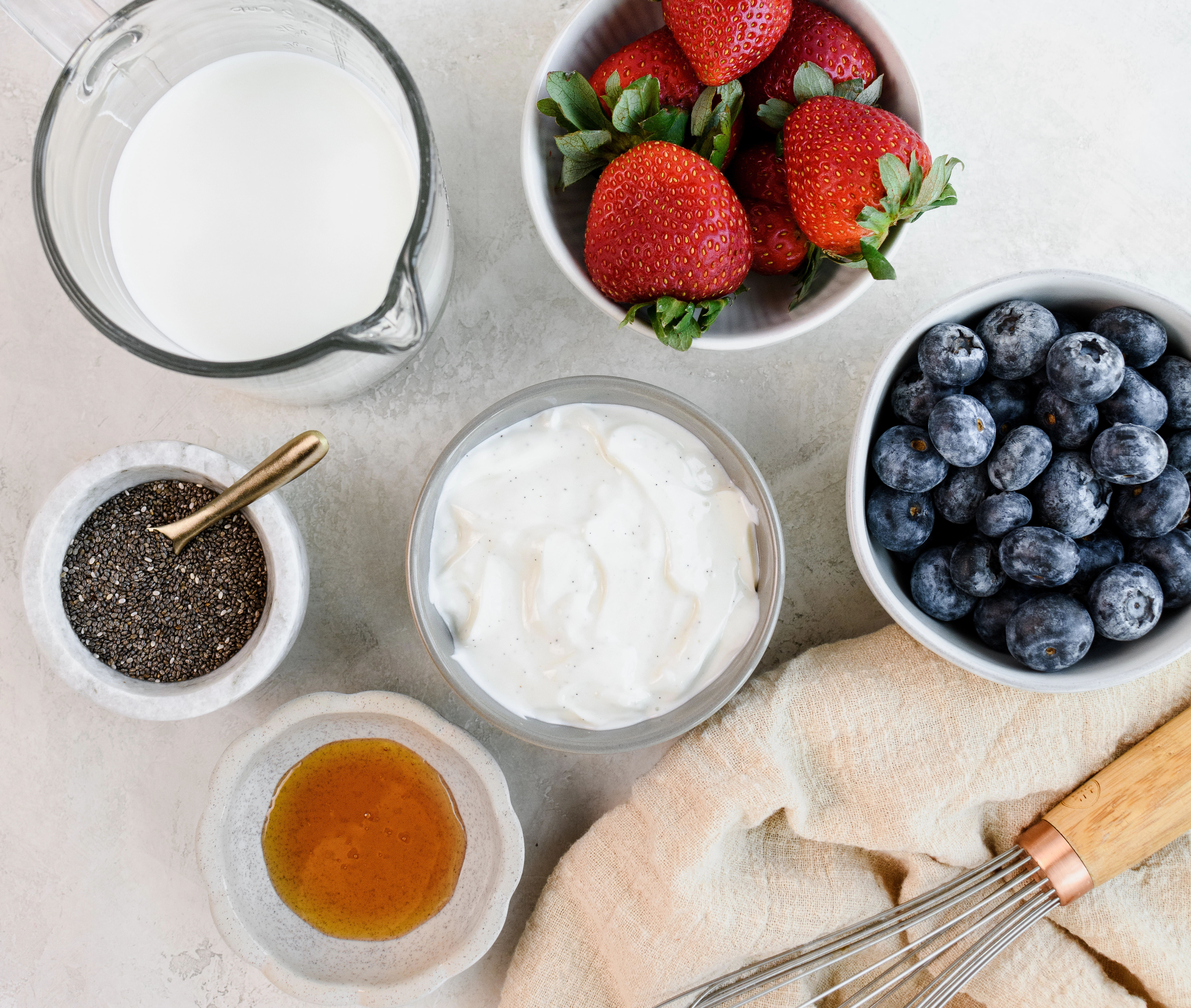 Greek yogurt chia seed pudding ingredients including honey, fruit, Greek yogurt, and chia seeds.