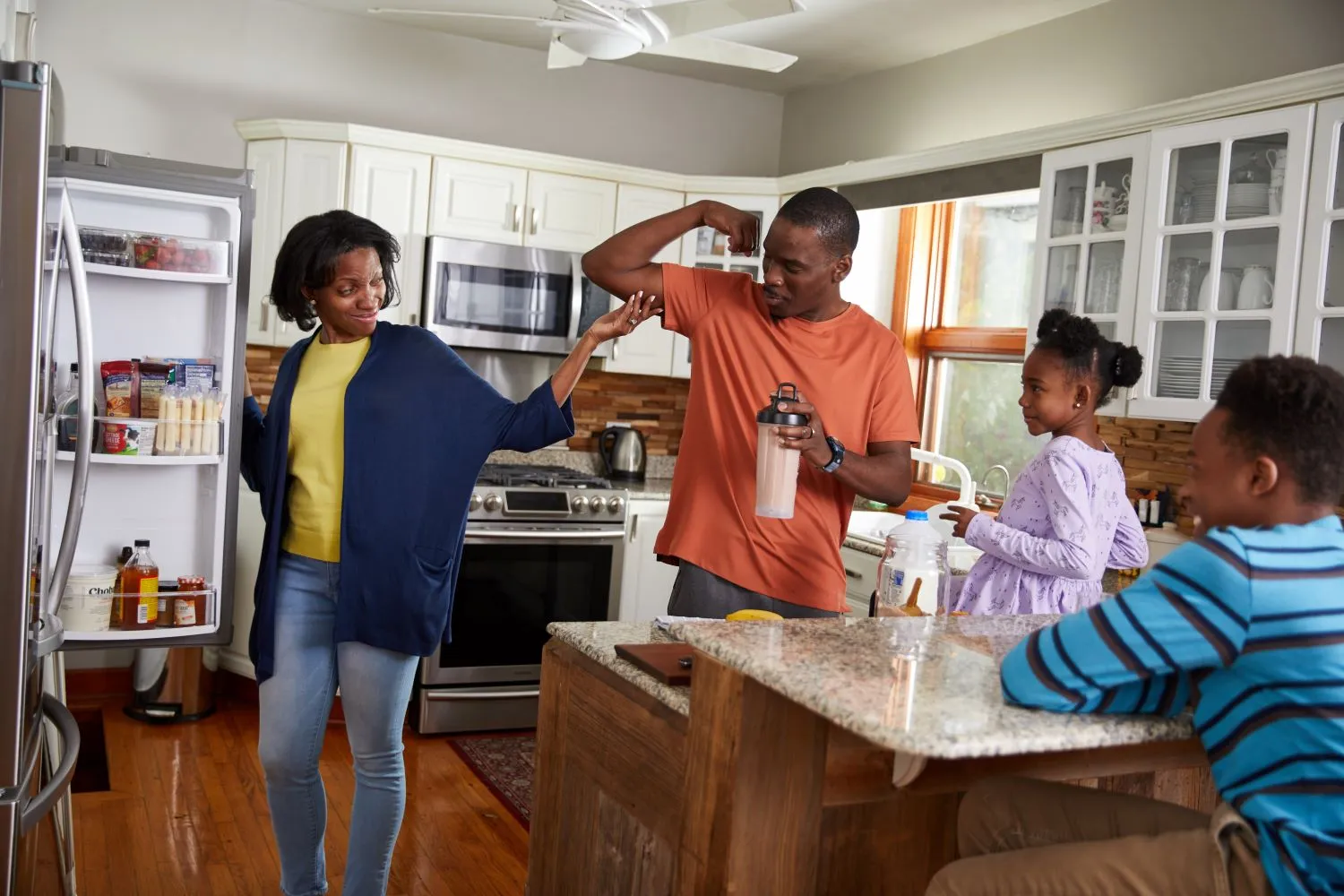 A family with a father flexing his arm to show the protein in milk has contributed to his muscles growing