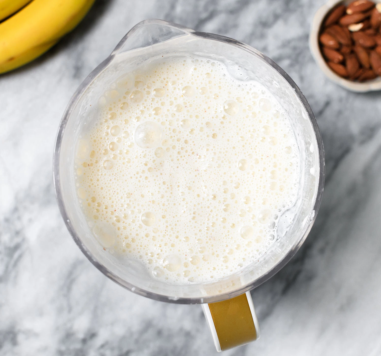 Blended banana smoothie with vanilla yogurt and almonds.