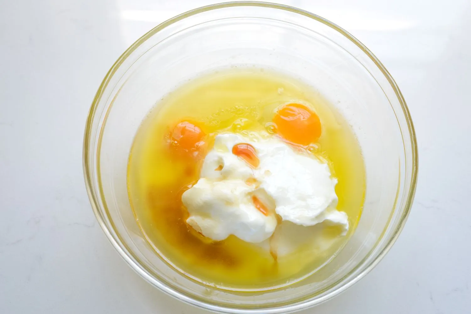 A large bowl filled with flour, baking powder, baking soda, and salt.