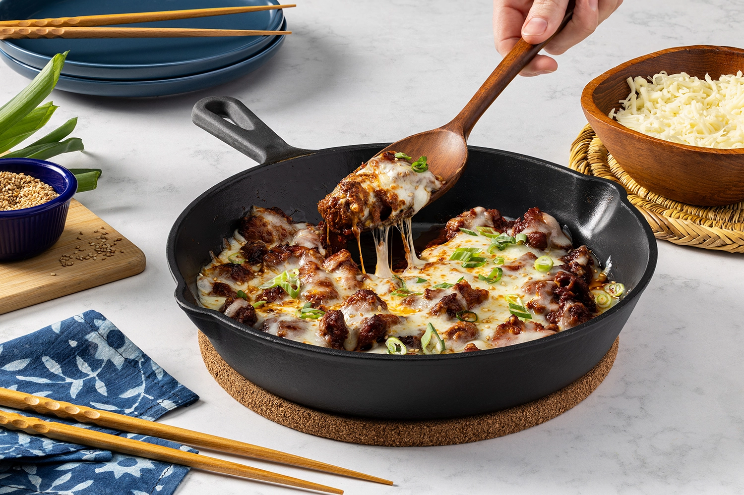Korean-style buldak chicken topped with melted cheese in a skillet, serving 6 people.