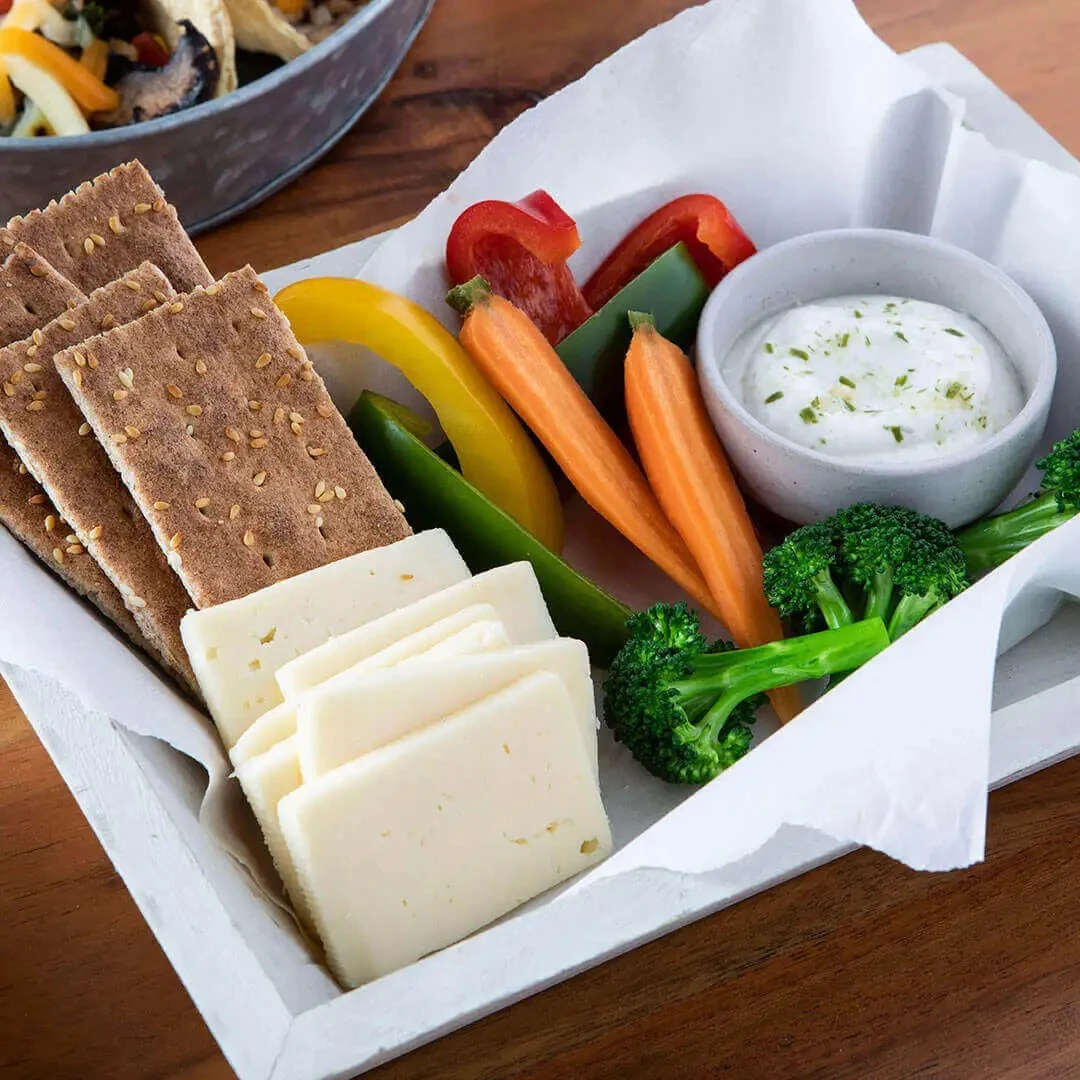 Creamy ranch greek yogurt dip paired with crackers and vegetables.