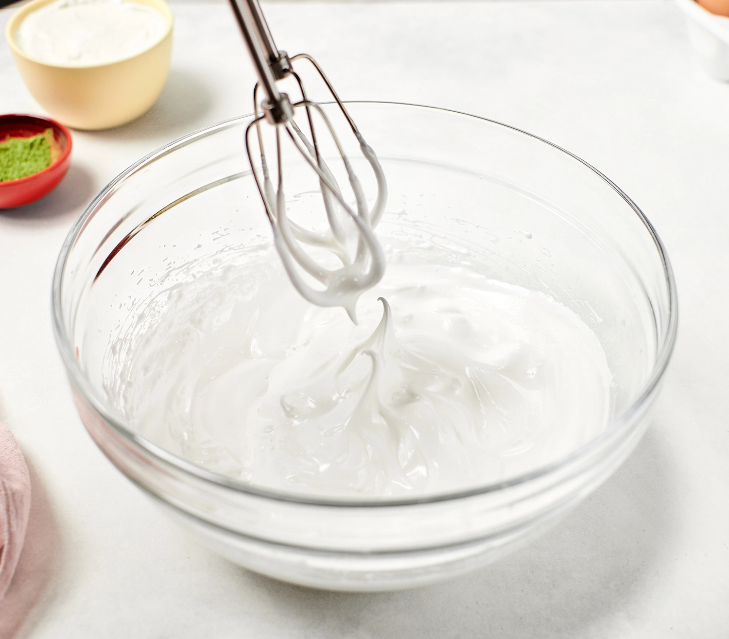 Whipping egg white meringue with a hand mixer.