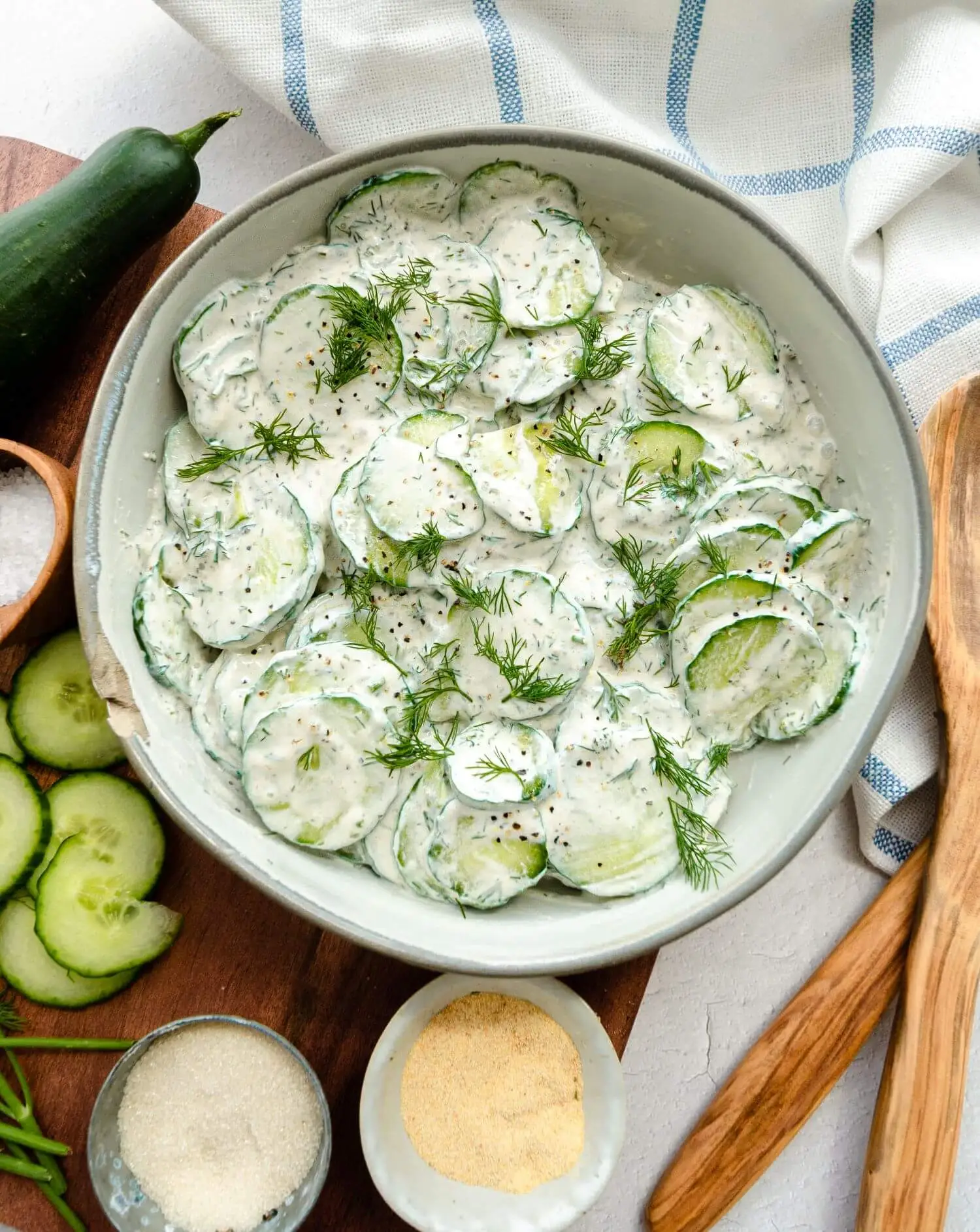 The cucumber salad being served after it was tossed in a homemade dressing.
